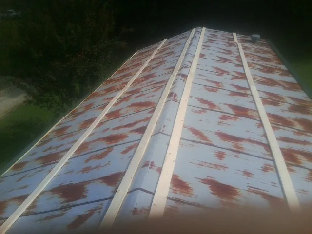Rusted metal roof panels with new wood purlins before replacement — Storm Damage Roof Repair in Warm Springs by Roofing Brothers