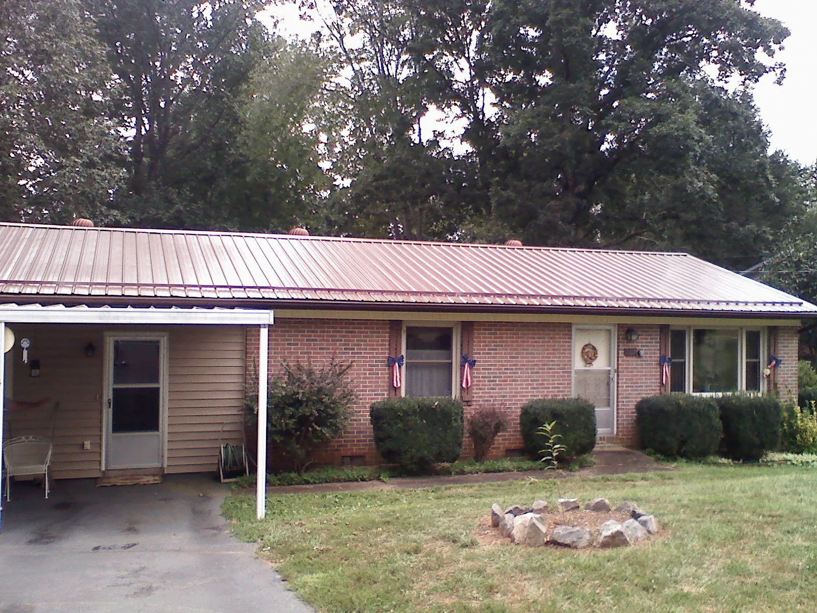 Bronze metal roof and carport on a brick ranch home — Roof Repair work by our crew in Warm Springs